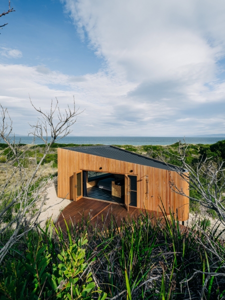 Деревянный домик в стиле &laquo;Tiny-house&raquo; среди песчаных дюн