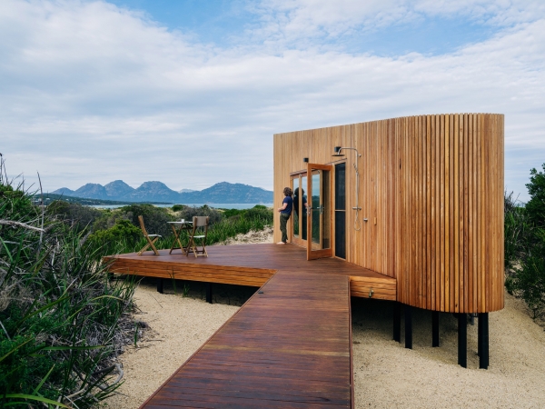 Деревянный домик в стиле &laquo;Tiny-house&raquo; среди песчаных дюн