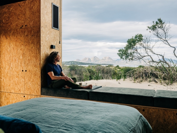 Деревянный домик в стиле &laquo;Tiny-house&raquo; среди песчаных дюн